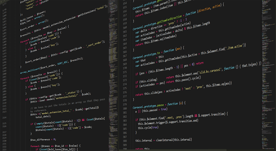 A person using a laptop with a coding or programming interface displayed on the screen, sitting at a white desk against a wooden wall background. The laptop screen shows multiple lines of code with sy